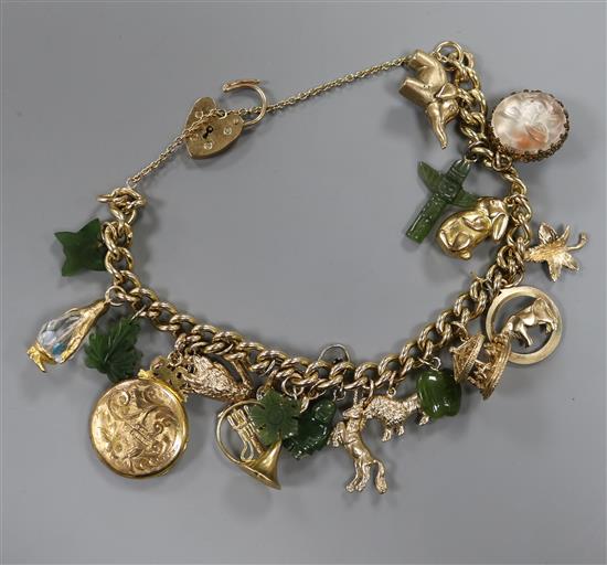 A yellow metal curb-link bracelet with padlock clasp, hung with 21 various charms